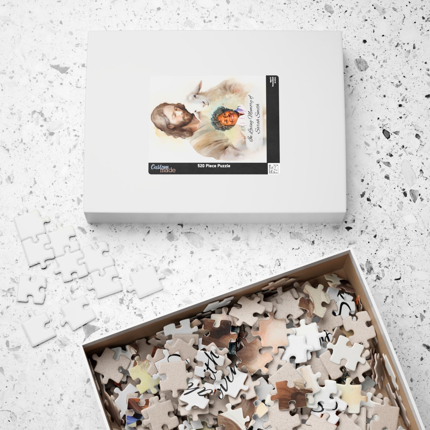 Personalized memorial puzzle box with 520 pieces, featuring a sacred shepherd design with Jesus holding a lamb and a photo of Sarah Smith, personalized with "In Loving Memory of Sarah Smith," with pieces inside the box.