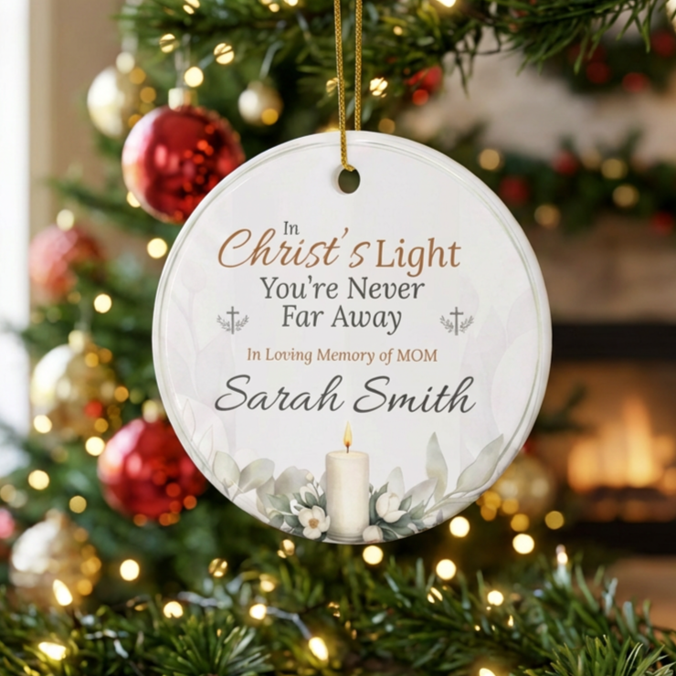 Decorative Christmas ornament with text and candle design, hanging on a decorated tree.