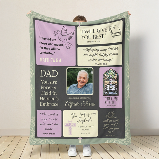 Memorial blanket with verses and a photo of a man, held by a person on a wooden floor.