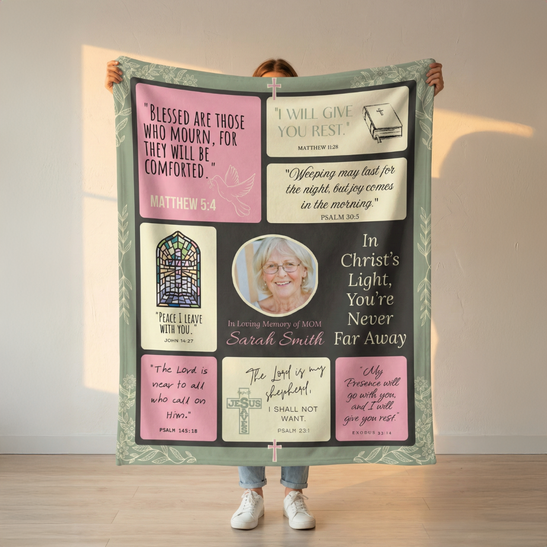 Person holding a large personalized blanket with religious quotes and a photo of a woman.
