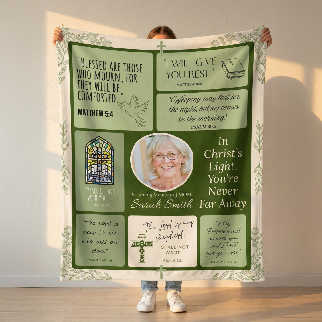Person holding a large green blanket with religious text and images.
